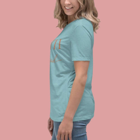 Faith looks good on you tee in Blue Lagoon color on a model against a pink background.
