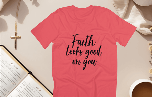 Faith Looks Good on You Tee displayed in coral with cursive text on back, styled with a bible and coffee.