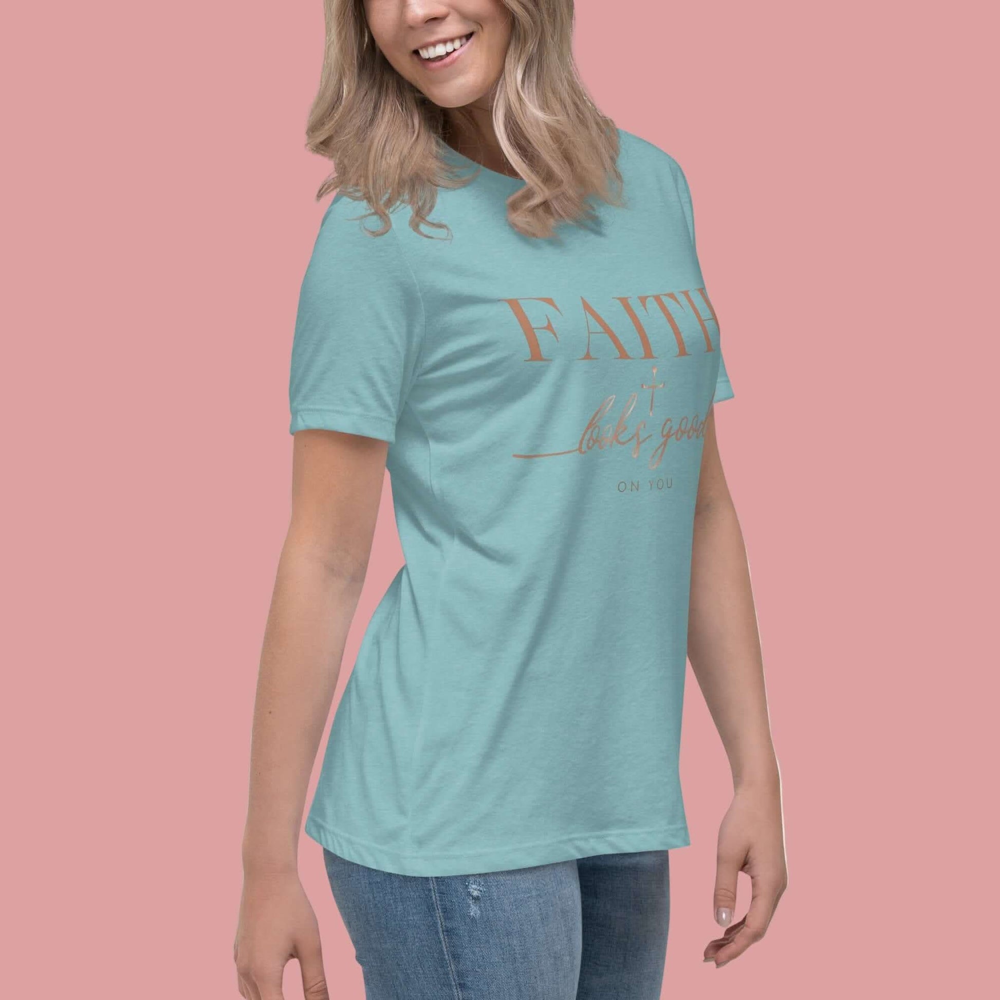A woman wearing the Faith Looks Good on You Tee in Blue Lagoon, showcasing its vibrant color and inspirational message.